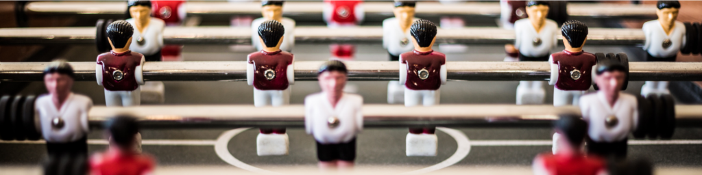 Picture of a foosball table, closely taken so that the players are close to the eye